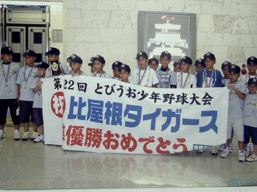 空港で横断幕と集合写真